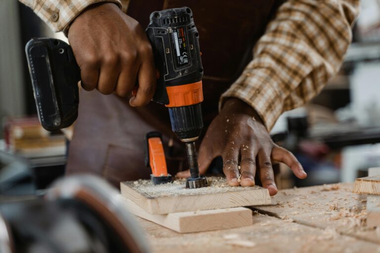 A craftsman skillfully uses a drill on a wooden board, showcasing woodworking precision.